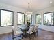 Bright dining area with large windows, modern chandelier, and view of trees outside at 914 Laurel Creek Ln, Charlotte, NC 28211