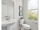 This bright half bathroom features an elegant pedestal sink and modern fixtures at 1015 Kokomo Ln # 22, Charlotte, NC 28206