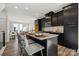Stylish kitchen island featuring bar stool seating, dark cabinets, and stainless steel appliances at 1015 Kokomo Ln # 22, Charlotte, NC 28206