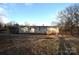 Back view of the mobile home with a large yard and wooden deck at 4223 Old Catawba Rd, Claremont, NC 28610