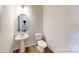 Cozy powder room featuring a pedestal sink, round mirror, and modern fixtures, providing a convenient and stylish space for guests at 4223 S New Hope Rd # 8, Cramerton, NC 28032