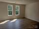 Bedroom with wood flooring and two large windows allowing ample natural light at 4229 S New Hope Rd # 11, Cramerton, NC 28032