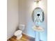 A well-lit powder room features a pedestal sink, oval mirror, and a toilet against a light-colored wall at 4227 S New Hope Rd # 10, Cramerton, NC 28032