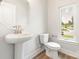 Bathroom features a pedestal sink, a toilet, and a window with natural light at 413 Prine Pl # Brx0014, Charlotte, NC 28213