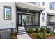 A covered front porch with room for seating is the focal point of this townhome at 413 Prine Pl # Brx0014, Charlotte, NC 28213