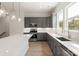 Well-lit kitchen boasts sleek, gray cabinets, stainless appliances, and an island with white countertop at 413 Prine Pl # Brx0014, Charlotte, NC 28213