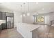 Kitchen showcases grey cabinets, stainless fridge, and a central island next to the living area at 413 Prine Pl # Brx0014, Charlotte, NC 28213