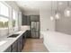 Kitchen with sleek gray cabinets, white backsplash, stainless steel appliances, and long countertops at 413 Prine Pl # Brx0014, Charlotte, NC 28213