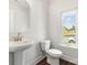 Bathroom with pedestal sink, toilet, and window with natural light at 417 Prine Pl # Brx0013, Charlotte, NC 28213