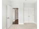 Bedroom featuring double doors, neutral walls, light carpeting, and an adjacent hallway at 417 Prine Pl # Brx0013, Charlotte, NC 28213