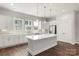 Spacious kitchen boasts white cabinets, stainless steel appliances, an island, and hardwood floors at 417 Prine Pl # Brx0013, Charlotte, NC 28213