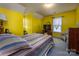 Sunny bedroom features colorful bedding, bright yellow walls, and lots of natural light at 166 Rosalind Ln, Statesville, NC 28677