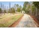 Gravel driveway leading up to a house, framed by fields and trees at 166 Rosalind Ln, Statesville, NC 28677