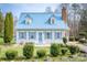 Charming home featuring a light blue metal roof, lush landscaping, and welcoming front yard at 166 Rosalind Ln, Statesville, NC 28677