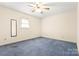 This bedroom features neutral paint, a ceiling fan, a window with blinds, and blue carpeting at 1302 Hickory Nut Ln, Lincolnton, NC 28092