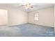 This bedroom features neutral paint, a ceiling fan, a window with blinds, and blue carpeting at 1302 Hickory Nut Ln, Lincolnton, NC 28092