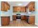 Traditional kitchen with wood cabinets, stainless steel appliances, and durable floors at 1302 Hickory Nut Ln, Lincolnton, NC 28092