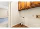 The laundry room features wood grain floors, overhead wooden cabinets, and washer and dryer hookups at 1302 Hickory Nut Ln, Lincolnton, NC 28092
