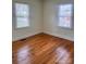 Well-lit bedroom featuring hardwood floors and two windows at 3918 Barlowe Rd, Charlotte, NC 28208