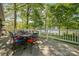 Outdoor deck with dining table, chairs, and railing overlooking the lake at 501 Nivens Cove Rd, Mount Holly, NC 28120