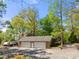 Charming detached two-car garage with stone facade and a large driveway surrounded by mature trees at 501 Nivens Cove Rd, Mount Holly, NC 28120