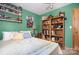 Green bedroom with a bed and shelves filled with books and collectables at 3220 Sawmill Rd, Hickory Grove, SC 29717