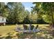 Stone fire pit surrounded by chairs in backyard at 3220 Sawmill Rd, Hickory Grove, SC 29717