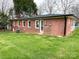 A brick home with a well-maintained lawn and mature trees in the backyard at 612 Brown Ave, Albemarle, NC 28001