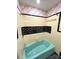 A retro bathtub is surrounded by classic yellow tile, black trim, and colorful wallpaper at 612 Brown Ave, Albemarle, NC 28001