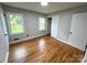 A cozy bedroom featuring hardwood floors and two windows offering pleasant outdoor views at 612 Brown Ave, Albemarle, NC 28001