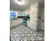 Bright kitchen displaying retro turquoise oven and patterned flooring, complemented by white cabinets at 612 Brown Ave, Albemarle, NC 28001