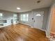 Well-lit living area with hardwood floors, built-in shelving, and a glimpse into the patterned-floor foyer at 612 Brown Ave, Albemarle, NC 28001