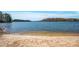 Sandy lakeshore with calm water and beautiful forest views at 121 Pebble Creek Dr, Stony Point, NC 28678