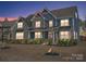 Evening view of a two-story house with lights on, showcasing its architectural details at 15827 Arabian Mews Ln, Charlotte, NC 28278