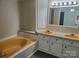Bright bathroom with a yellow soaking tub, double vanity, and light fixtures at 230 Ellen St, Salisbury, NC 28146