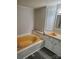 Bathroom features a yellow soaking tub, vanity, mirror, and gray wood-look floors at 230 Ellen St, Salisbury, NC 28146