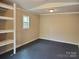 Empty room features neutral walls, gray flooring, built-in shelves, and a window for natural light at 230 Ellen St, Salisbury, NC 28146