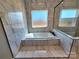 This bathroom features marble tiling and a soaking tub with windows at 3251 Wilson Ct # 10, Lincolnton, NC 28092