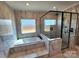 This bathroom features marble tiling, a glass shower, and a soaking tub with windows at 3251 Wilson Ct # 10, Lincolnton, NC 28092