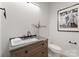 Modern bathroom with dark vanity, a white sink, and a frameless shower at 130 Cherokee Rd # 404, Charlotte, NC 28207