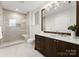 Elegant bathroom with a walk-in shower, toilet, and dark brown vanity at 130 Cherokee Rd # 404, Charlotte, NC 28207