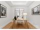 Serene home office features a simple wooden desk, comfortable chair, and large mirrors at 130 Cherokee Rd # 404, Charlotte, NC 28207