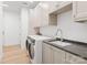 Bright laundry room with modern washer, dryer, and ample cabinetry at 130 Cherokee Rd # 105, Charlotte, NC 28207