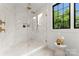 Modern bathroom featuring glass enclosed shower with gold hardware and marble tiling at 4142 Pineview Rd, Charlotte, NC 28211