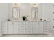 Double vanity in bathroom with white cabinets, gold hardware, and white tile walls at 4142 Pineview Rd, Charlotte, NC 28211