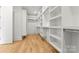 Spacious walk-in closet with custom shelving and wood flooring at 4142 Pineview Rd, Charlotte, NC 28211