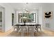 Modern dining room with a large black table, six chairs, modern chandelier, and large windows at 4142 Pineview Rd, Charlotte, NC 28211
