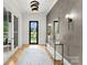 Elegant foyer with stylish lighting, decorative mirror, console table, and view of the outdoors through a black framed door at 4142 Pineview Rd, Charlotte, NC 28211
