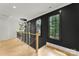 Upstairs hallway features hardwood floors, black trim windows and modern railing at 4142 Pineview Rd, Charlotte, NC 28211