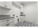 Clean laundry room with white cabinets, stone countertops, and patterned tile flooring at 4142 Pineview Rd, Charlotte, NC 28211